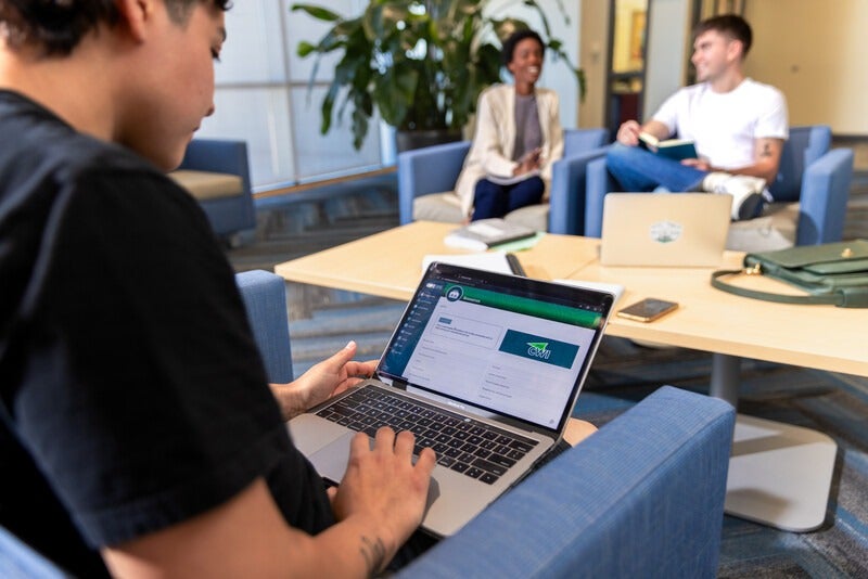 Student working on computer in common area on campus