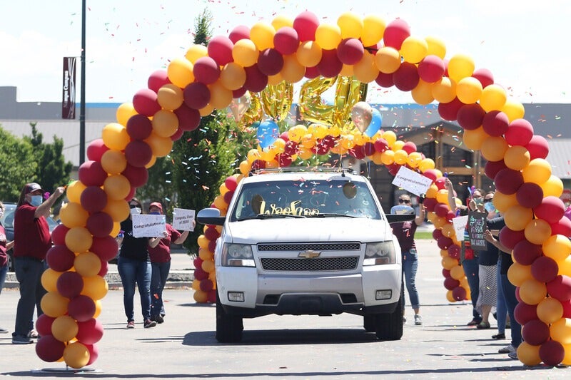 Vehicle driving through balloon arches during Grad Fest