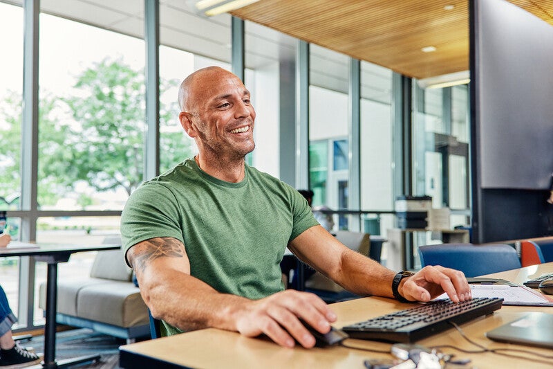 Smiling student sitting at a computer