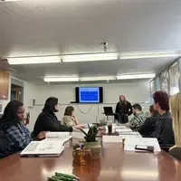 Group of people sit at table with papers in front of them