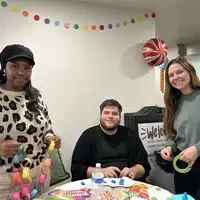 Three people doing activities at a table