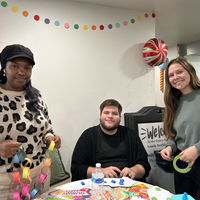 Three people doing activities at a table