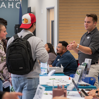 People chatting near table and brochures