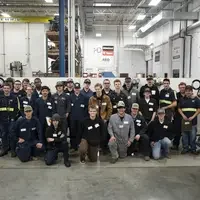 Group of people standing together in a automotive lab
