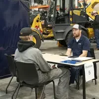 Two people sit at a table across from each other