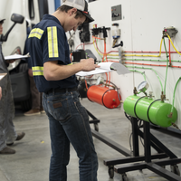 Person standing with a clipboard and writing down items