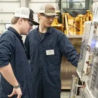 Two people standing together looking at a board
