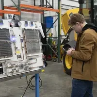 Person standing and writing with a clipboard in front of board