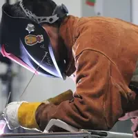 Student with helmet on while welding