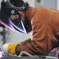 Student with helmet on while welding