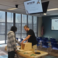 Students in a room with a table working on a kestrel box