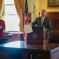 Governor stands behind podium with proclamation in hand