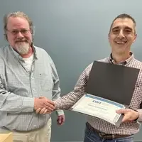 Two people standing together holding a certificate
