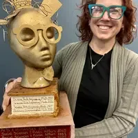 Person holding a trophy head with glasses
