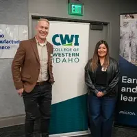 Apprentice and instructor in front of CWI banner