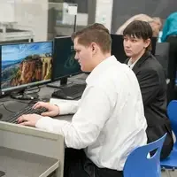 Students working together on dual computer screens