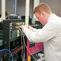 Students working on computer with wires