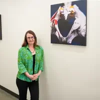 Holly Bale stands next to piece of art