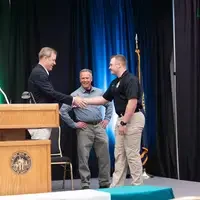 Graduate walking across stage to shake hands