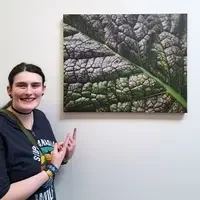 Kaylee Pearson stands next to photo