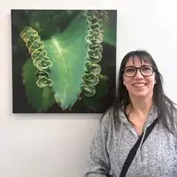 Kelly Rice stands next to photo