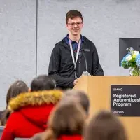 Josiah Kalousek speaking at podium
