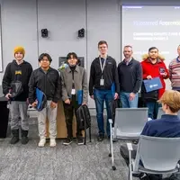 Graduates stand in front of audience