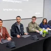 New Apprentices sit at a table and sign their paper