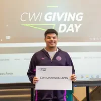 Student holding sign expressing gratitude at Giving Day