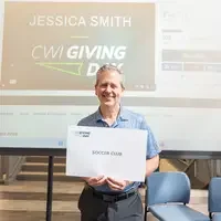 Man holding sign that says "Soccer Club"