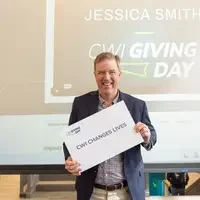 President Gordon Jones holding thank you sign