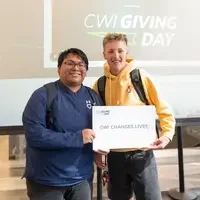 Two students hold thank you sign