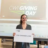 Student holding sign that says, "CWI CHANGES LIVES"