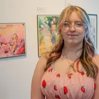 Student in front of a couple pieces of wall art
