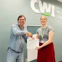 Two people shake hands and hold up certificate 