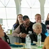 People sit at table and listen on