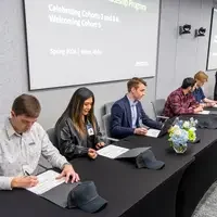 Micron Apprentices signing forms at a table