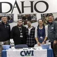Five people stand in front of a table