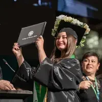 Graduate holds up a degree