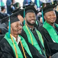 Three graduates sitting and smiling