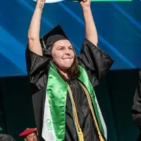 Graduate holding up a degree above their head