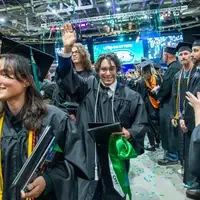 Graduate with hand above their head
