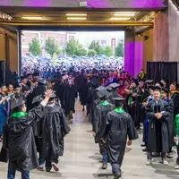 Graduates walk out of auditorium 