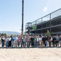 Group of people stand in front of beam