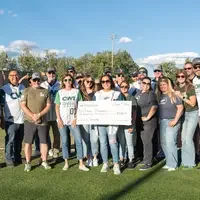 group of people hold giant check