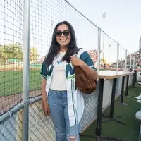 Jacqui Villasenor stands in front of fence