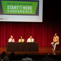 Panelists talk on a stage