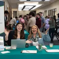 Two people sitting at a check in table