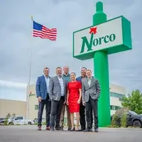 Group shot of Norco employees in front of Norco sign
