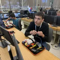 Student working with wires at computer